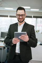 Fototapeta premium Vertical image of Bearded business man using tablet computer