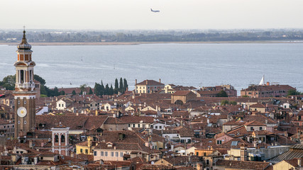 An airplane landing over the historic center of Venice, Italy, viewed from above