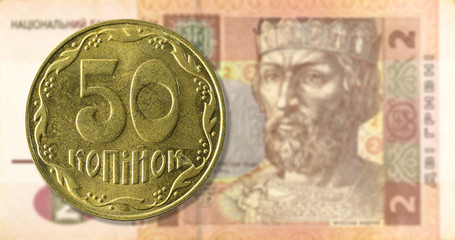 50 kopiyka coin against 2 ukrainian hryvnia bank note obverse