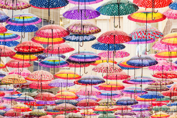 Colorful umbrellas on the ceiling of the largest mall in the world Dubai Mall UAE.
