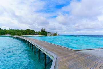 Wooden bridge and beautiful crystal clear sea on tropical Maldives island