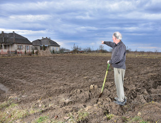 Farmer standing with a shovel on the field