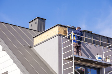 Roofer assembles sheet metal on the roof. Roofers on the roof.