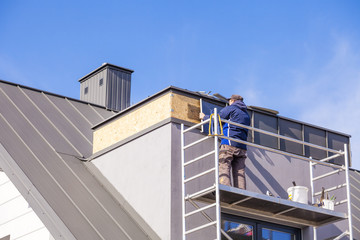 Roofer assembles sheet metal on the roof. Roofers on the roof.