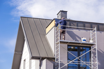 Roofer assembles sheet metal on the roof. Roofers on the roof.