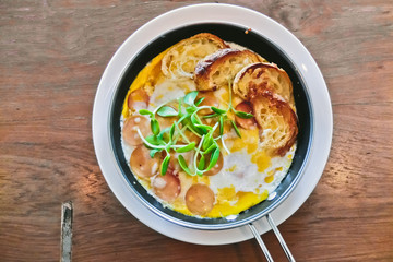 breakfast: fried eggs with croissants and sausage in pan