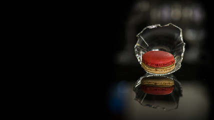 Sweet and colorful french macaroon (macaron) with reflection on solid black background