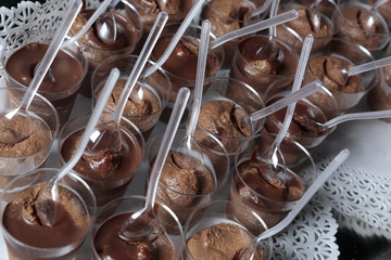 Deliziosi dolcetti alla cioccolato bicchierini di plastica trasparente con il cucchiaino disposti...