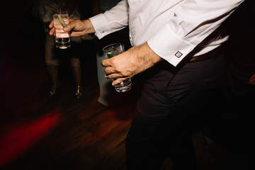 Gin and tonic with cucumber cocktail in man hands