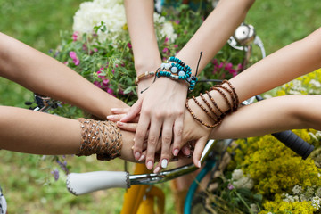 United hands of girlfriends closeup, young girls in boho bracelets