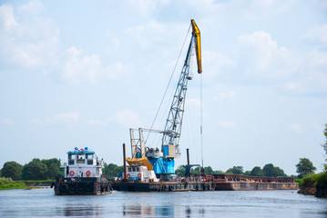 Fototapeta premium The cargo barge floats on the river