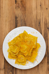 boiled ravioli with cheese on white plate