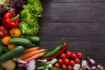 Border of fresh vegetables on wooden background with copy space