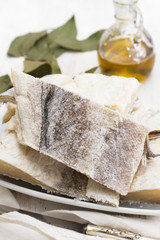 Obraz na płótnie Canvas salted raw dry cod fish on dish and olive oil
