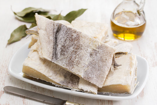 salted raw dry cod fish on dish and olive oil