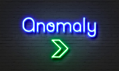 Anomaly neon sign on brick wall background.