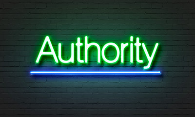 Authority neon sign on brick wall background.