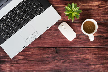 Top view of office stuff with laptop wireless mouse and coffee cup on wooden table.Concept workplace.