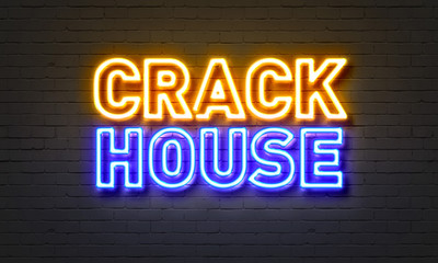 Crackhouse neon sign on brick wall background.