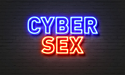 Cybersex neon sign on brick wall background.