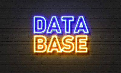 Database neon sign on brick wall background.