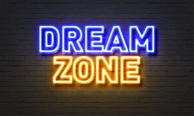 Dream zone neon sign on brick wall background.