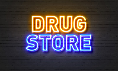 Drug store neon sign on brick wall background.