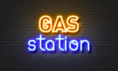 Gas station neon sign on brick wall background.