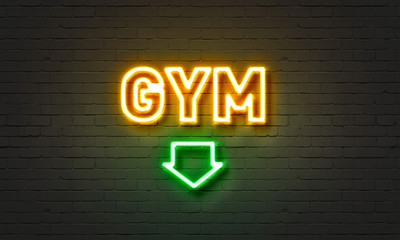 Gym neon sign on brick wall background.