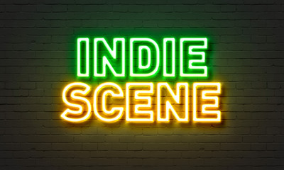 Indie scene neon sign on brick wall background.