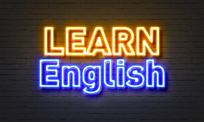 Learn English neon sign on brick wall background.