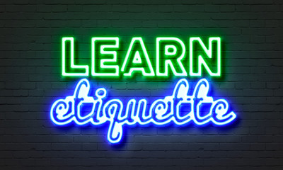 Learn etiquette neon sign on brick wall background.