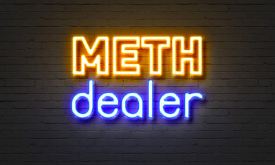 Meth dealer neon sign on brick wall background.