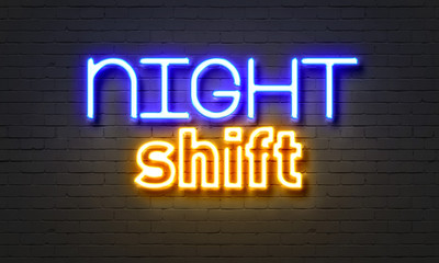 Obraz premium Night shift neon sign on brick wall background.