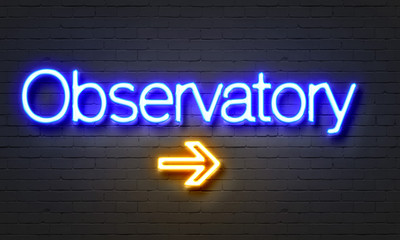 Observatory neon sign on brick wall background.