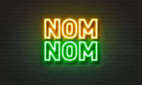 Nom nom neon sign on brick wall background.