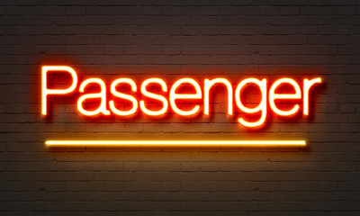 Passenger neon sign on brick wall background.