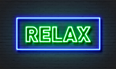 Relax neon sign on brick wall background.