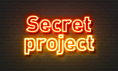Secret project neon sign on brick wall background.
