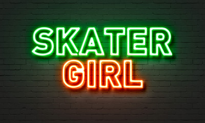 Skater girl neon sign on brick wall background.