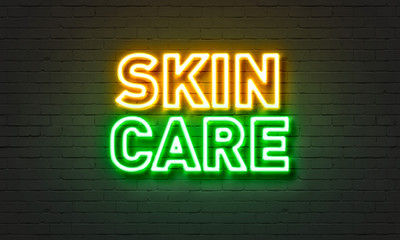 Skin care neon sign on brick wall background.
