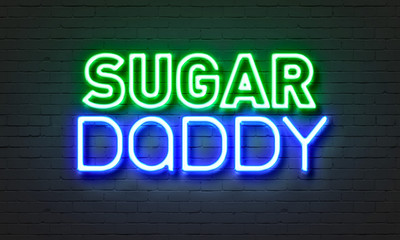 Sugar daddy neon sign on brick wall background.