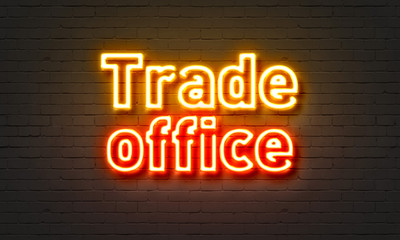 Trade office neon sign on brick wall background.