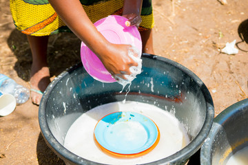 Obraz premium hand of african woman while washing dishes