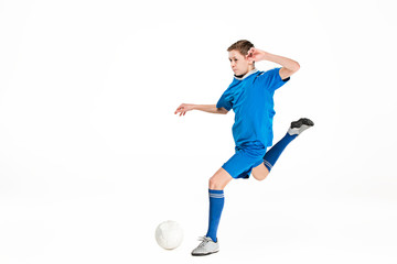 Fototapeta premium Young boy with soccer ball doing flying kick
