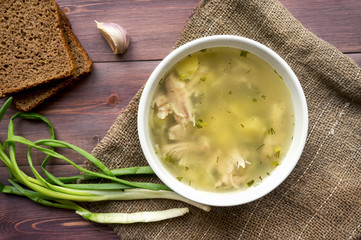 Chicken soup with noodle on wooden table. Rustic food photo. Top view