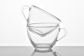 Two transparent glass cups on the white background