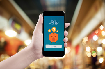 Woman hand holding the phone with saving money screen
