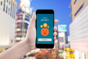 Woman hand holding the phone with saving money screen