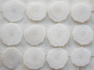 Fototapeta na wymiar Fresh Sliced White Radishes background (close-up shot)